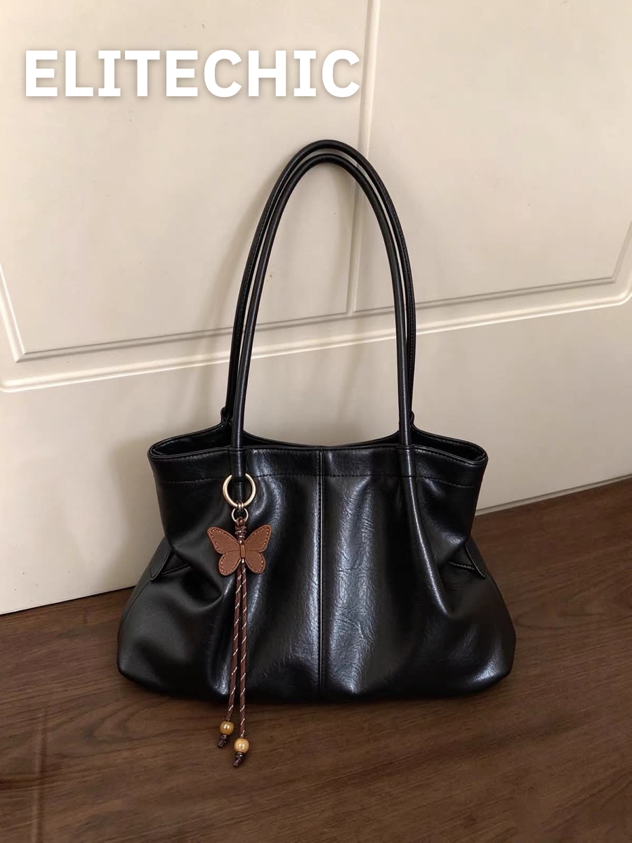 Túi tote da đen dáng mềm trên sàn gỗ