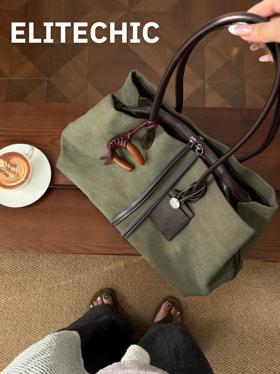 Túi tote canvas xanh rêu trên bàn gỗ cạnh tách cà phê