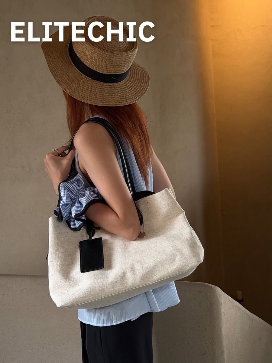 Cô gái đội mũ cói đeo túi tote canvas kem