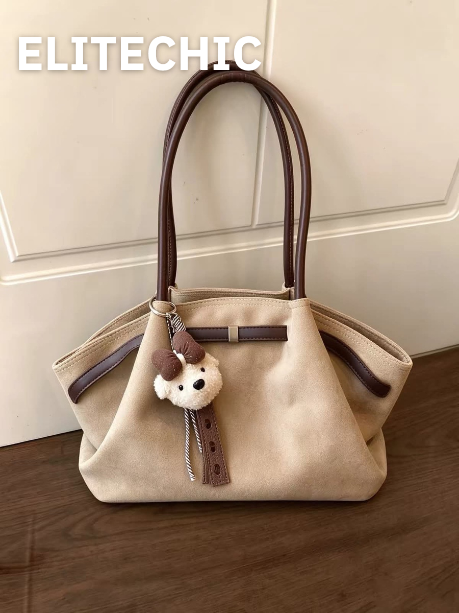 Túi tote da lộn kem viền nâu trên sàn gỗ
