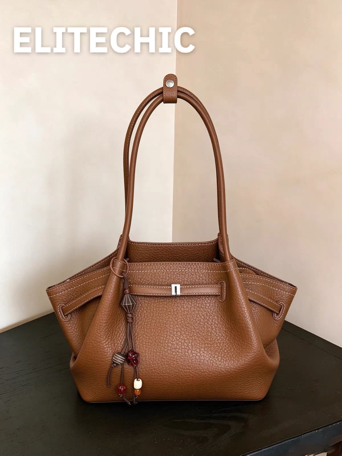 Mặt trước túi tote da vân sần màu nâu với đai khóa ngang